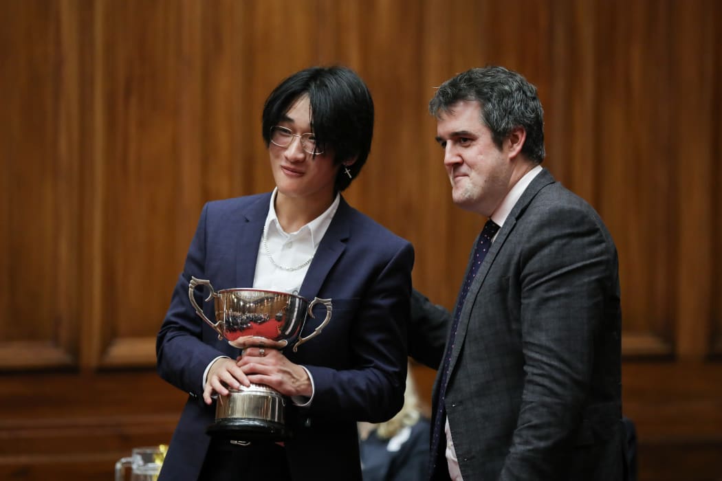 Chris Bishop poses for a photo with Tony Huang and speaking trophy.