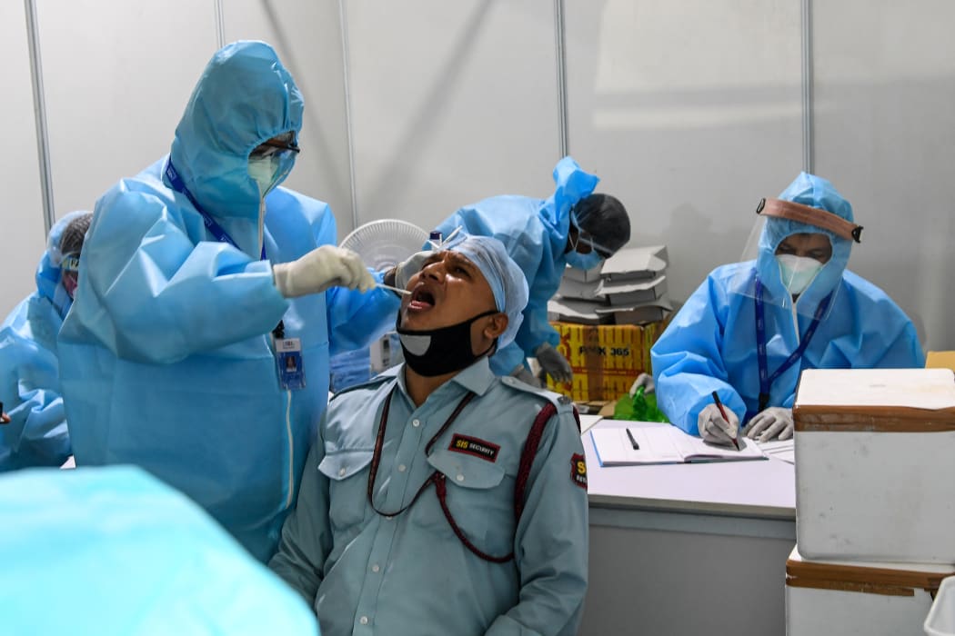 Medical staff taking a swab sample from a man at Dr Ram Manohar Lohia (RML) hospital in New Delhi on 31 July.