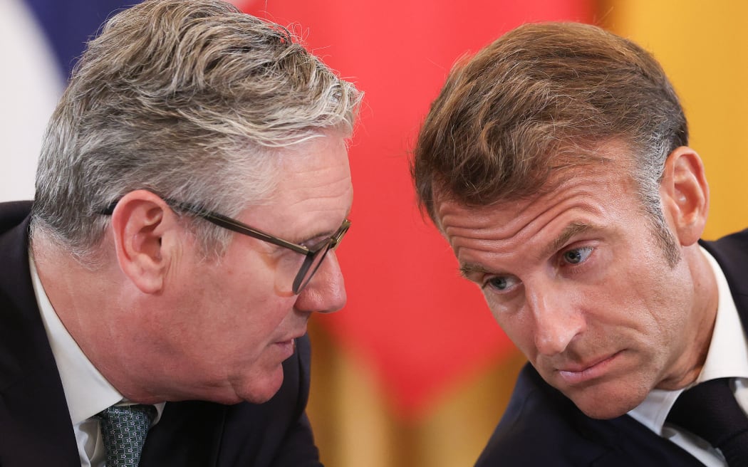 WASHINGTON, DC - AUGUST 18: British Prime Minister Keir Starmer (L) confers with French President Emmanuel Macron during a meeting U.S. President Donald Trump, Ukrainian President Volodymyr Zelensky and European leaders at the White House on August 18, 2025 in Washington, DC. President Trump hosted President Zelensky at the White House for a bilateral meeting and an expanded meeting with European leaders to discuss a peace deal between Russia and Ukraine.   Win McNamee/Getty Images/AFP (Photo by WIN MCNAMEE / GETTY IMAGES NORTH AMERICA / Getty Images via AFP)