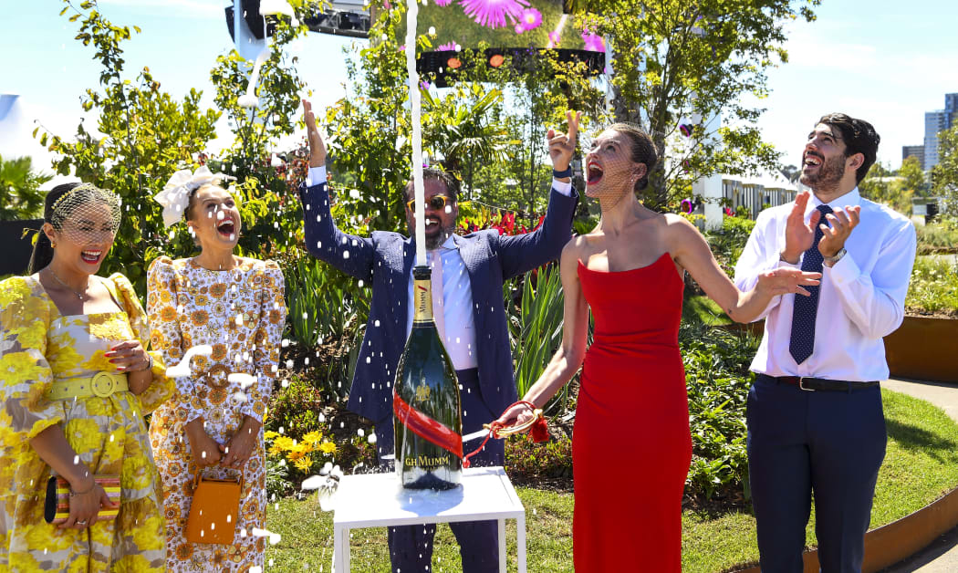 Model Montana Cox sprays chamapagne at the Flemington racecourse in Melbourne on November 1, 2021 ahead of the Melbourne Cup.