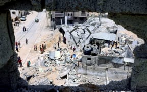 Palestinians inspect their house, after it was destroyed by an Israeli airstrike, in the city of Rafah, in the southern Gaza Strip on 16 May 2021.