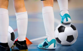 Indoor soccer players training with balls. Indoor soccer sports hall. Football futsal player, ball, futsal floor. Sports background. Futsal league. Indoor football players with classic soccer ball.