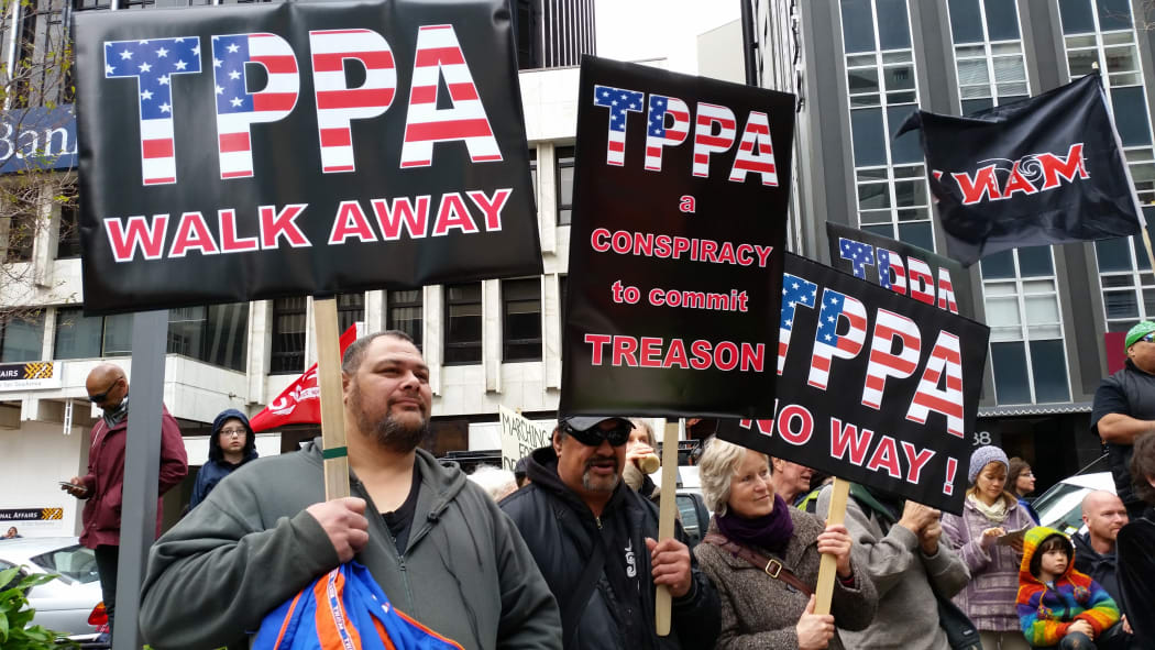The crowd preparing to march on parliament in Wellington with anti-corporation slogans and signs.
