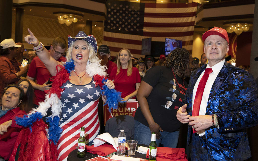 Stephanie Smith, left, and Thomas Brewer react to election results at the Nevada GOP election watch party in Las Vegas, Nevada on November 5, 2024. (Photo by Ronda Churchill / AFP)