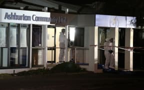 Members of the police forensics team leave the Ashburton Work and Income office, where three women were shot, two fatally.