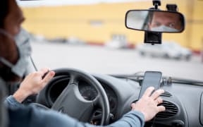 Taxi driver using phone for navigation.