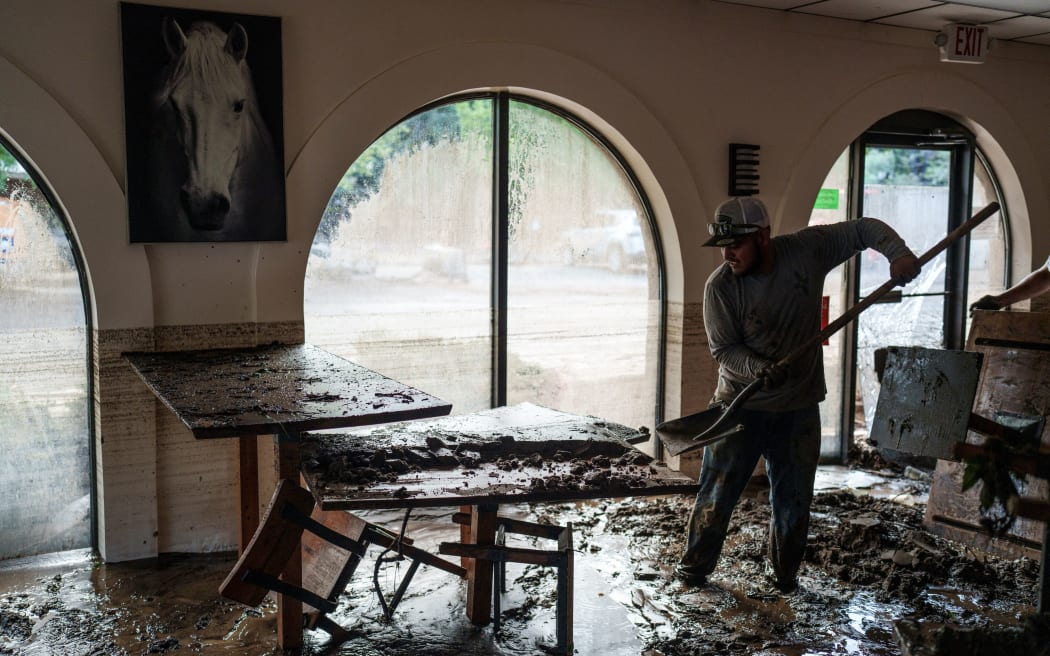 Omar Gutierrez, 31, helps clear debris from the inundated dining area of La Salsa Kitchen, a Mexican restaurant, after deadly flash flooding in Ruidoso, New Mexico, July 9.