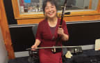 Nancy poses with traditional Chinese instrument called an er hu