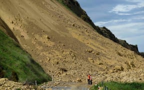 Emergency services officers inspect the damage caused to Rotherham Road near Waiau town.