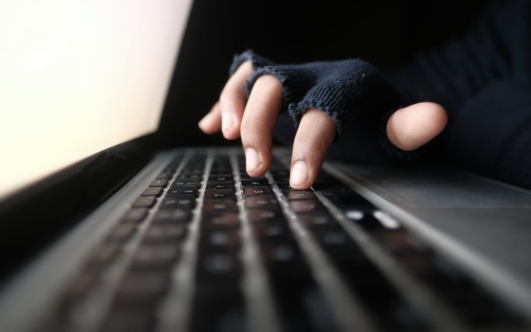 hacker hand stealing data from laptop top down.