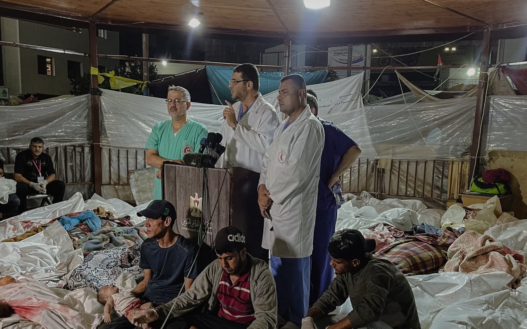 Amid the tragic aftermath of the bombing of Gaza's Al-Ahli Baptist Hospital on October 17, 2023, doctors at Al-Shifa Hospital gather to make a press statement, surrounded by Palestinian bodies. Photo by Mohamed Masri / Middle East Images / Middle East Images via AFP