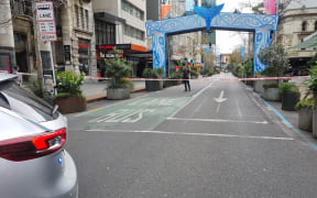 Armed police stand behind a cordon on Auckland's Queen Street following a serious shooting incident in the CBD on 20 July, 2023.