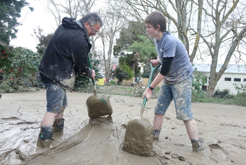 People in Whanganui work to clean up flooding at Anzac Parade.