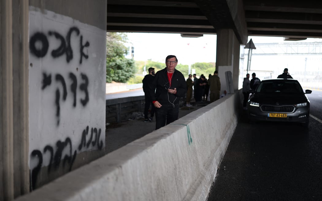 People take shelter under a bridge as sirens sounded near Tel Aviv on February 28, 2026, following the announcement that Israel had launched a “preemptive strike” on Iran. President Donald Trump urged Iranians on February 28 to take over their government as US forces began a large-scale attack on the country's military. (Photo by ilia YEFIMOVICH / AFP)