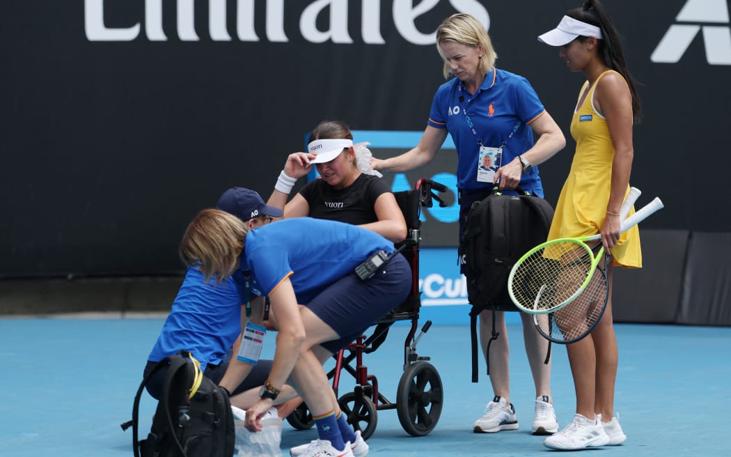 Canada's Marina Stakusic reacts in a wheelchair as she retires due to an injury while playing against Australia's Priscilla Hon (R) during their women's singles match on day two of the Australian Open tennis tournament in Melbourne on January 19, 2026. (Photo by IZHAR KHAN / AFP) / -- IMAGE RESTRICTED TO EDITORIAL USE - STRICTLY NO COMMERCIAL USE --