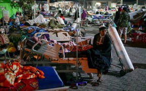Patients are seen outside of a public hospital in Lombok, Indonesia after the 6.9 magnitude quake hit.