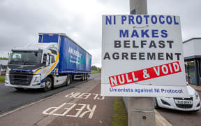 (FILES) In this file photo taken on May 17, 2022 A lorry passes an anti 'Northern Ireland (NI) Protocol' sign as it is driven away from Larne port, north of Belfast in Northern Ireland, after arriving on a ferry. - The prospect of a deal on post-Brexit trading arrangements in Northern Ireland appeared tantalisingly close on February 26, 2023 as British Prime Minister Rishi Sunak and European Commission chief Ursula von der Leyen announced they were to meet in the UK "for final talks". (Photo by Paul Faith / AFP)