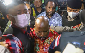 Police and Corruption Eradication Commission (KPK) officers escort Governor of Papua Lukas Enembe for medical check up at the Army hospital in Jakarta on January 10, 2023, following his arrest for an alleged bribery case of infrastructure development.