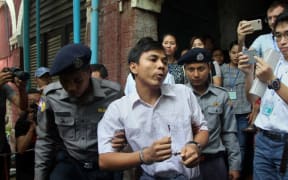 Detained Myanmar journalist Kyaw Soe Oo is escorted by police to a court.