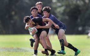 Hamilton Boys' High player Tre Poihipi is tackled by Rotorua Boys' High players, Tukimihia Simkins, left, and Poukohe Sorenson during the 2018 Condor 7s final.