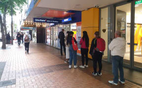 People queue outside a pharmacy today.
