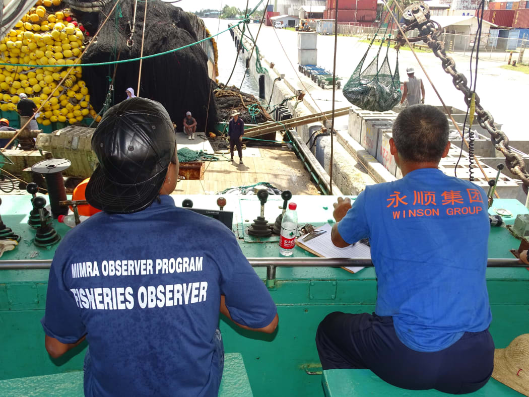 Monitors observing a purse seiner unloading in Majuro