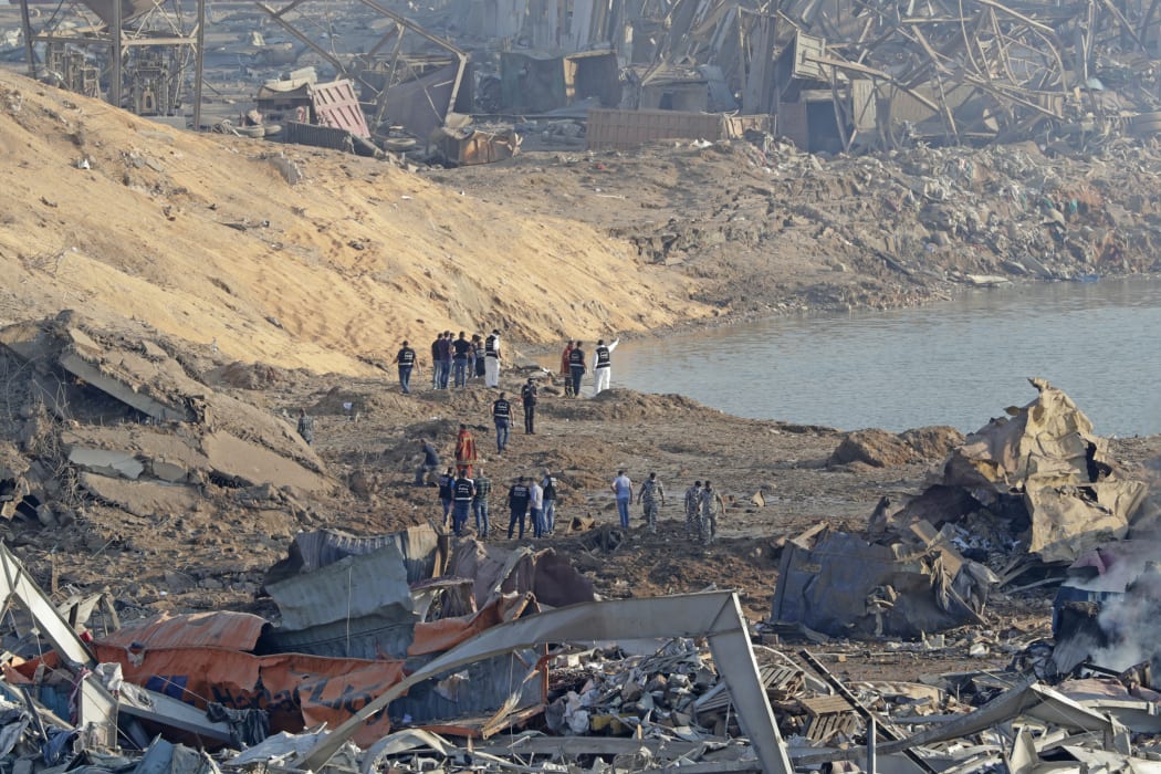 Police and forensic officers work at the scene of an explosion which took place yesterday at the port of Lebanon's capital Beirut.