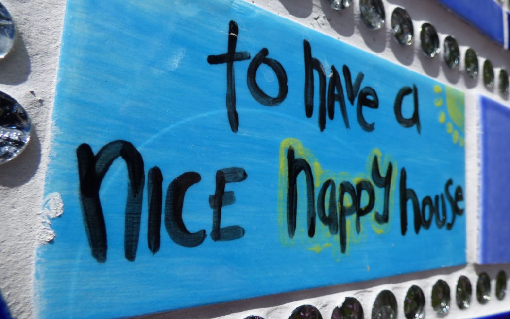 blue tile saying "to have a nice happy house"
