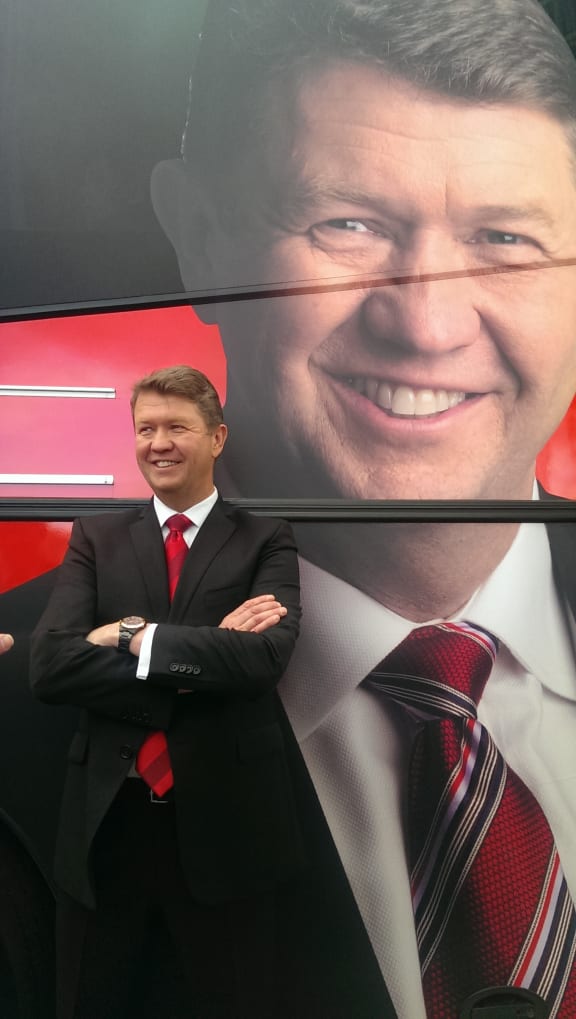 David Cunliffe standing in front of a campaign bus.