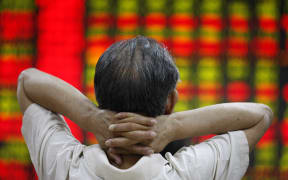 A man watches a screen board at a stocks market in Huaibei, east China's Anhui Province, July 6, 2015.