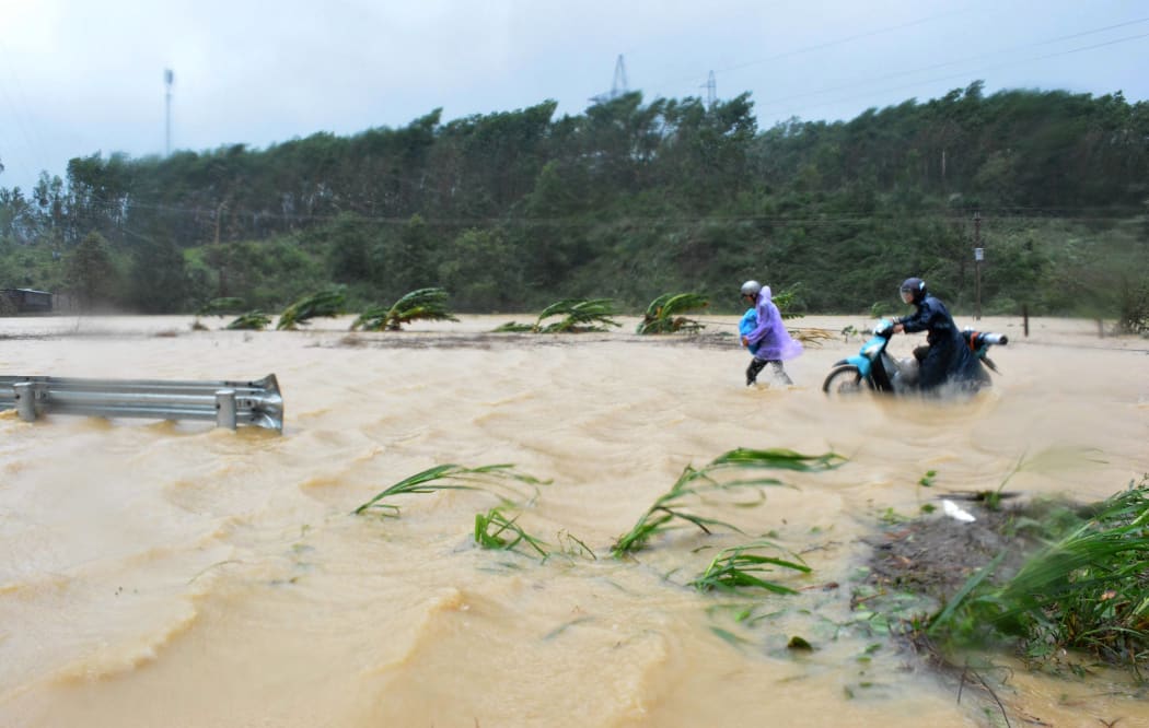 Walking through floodwaters on a highway in the central province of Dak Lak brought by Typhoon Damrey.