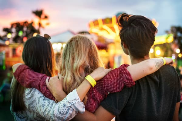 Three young friends hanging out, with arms around each other.