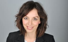 a portrait of Bridget Christie. She wears a blazer and a gig tshirt.