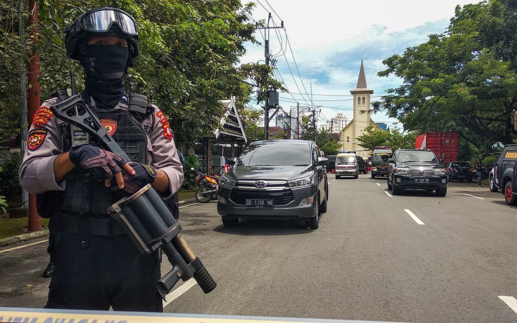 An Indonesian anti-terror policeman stands guard as police seal the area after an explosion outside a church in Makassar on March 28, 2021. (Photo by ANDI HAJRAMURNI / AFP)