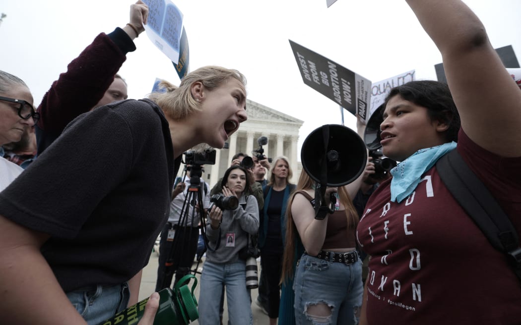 Pro-choice and anti-abortion activists yell at one another in front of the US Supreme Court building in Washington, DC on 3 May, 2022.