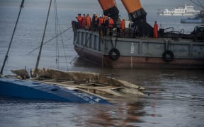 Chinese salvagers have begun to right an upturned ship on which more than 400 people are thought to have died.
