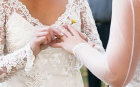 Same sex gay lesbian bride places ring on finger during wedding ceremony