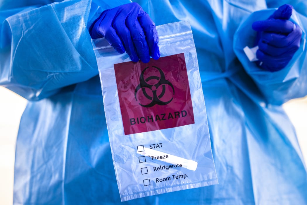 Covid-19 tester holds a bag after administering a test at Echo Park Stadium on December 30, 2020 in Parker, Colorado.