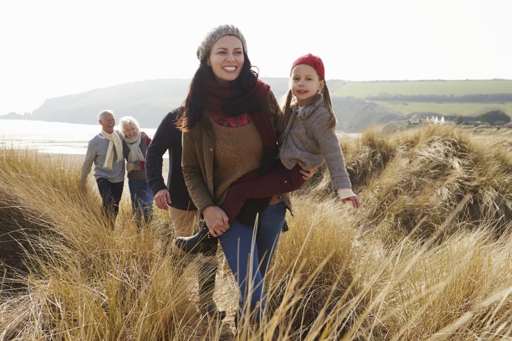 A photo of a Multi Generation Family In Sand Dunes On Winter Beach