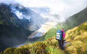A hiker walks along a trail in the Matukituki Valley in Mt Aspiring National Park.
