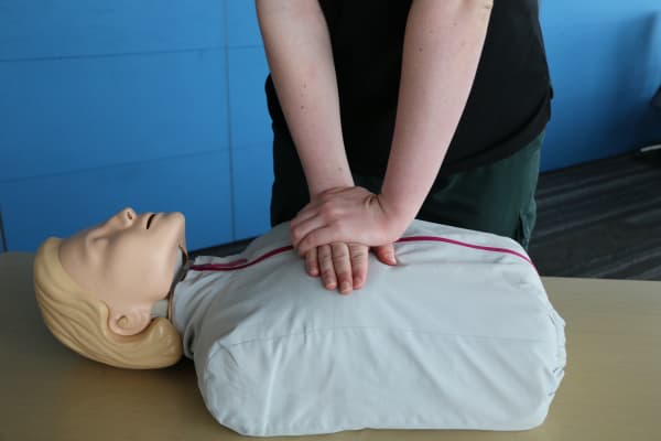 St John’s Three Steps for Life delivery lead Mia Noyes performing chest compression for CPR on a manikin.
