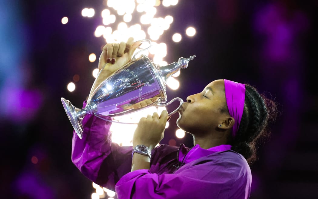 US' Coco Gauff celebrates with her winning trophy after defeating China's Zheng Qinwen in their women's singles final tennis match at the WTA Finals Championship in Riyadh on November 9, 2024. (Photo by Fayez NURELDINE / AFP)