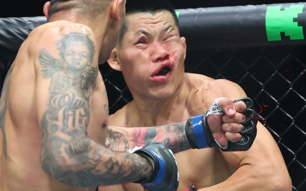 China's Li Jingliang (in red) is knocked out by Brazil's Carlos Prates in their men's welterweight division event of the Ultimate Fighting Championship (UFC) 305 at the Perth Arena in Perth on August 18, 2024. (Photo by COLIN MURTY / AFP) / -- IMAGE RESTRICTED TO EDITORIAL USE - STRICTLY NO COMMERCIAL USE --
