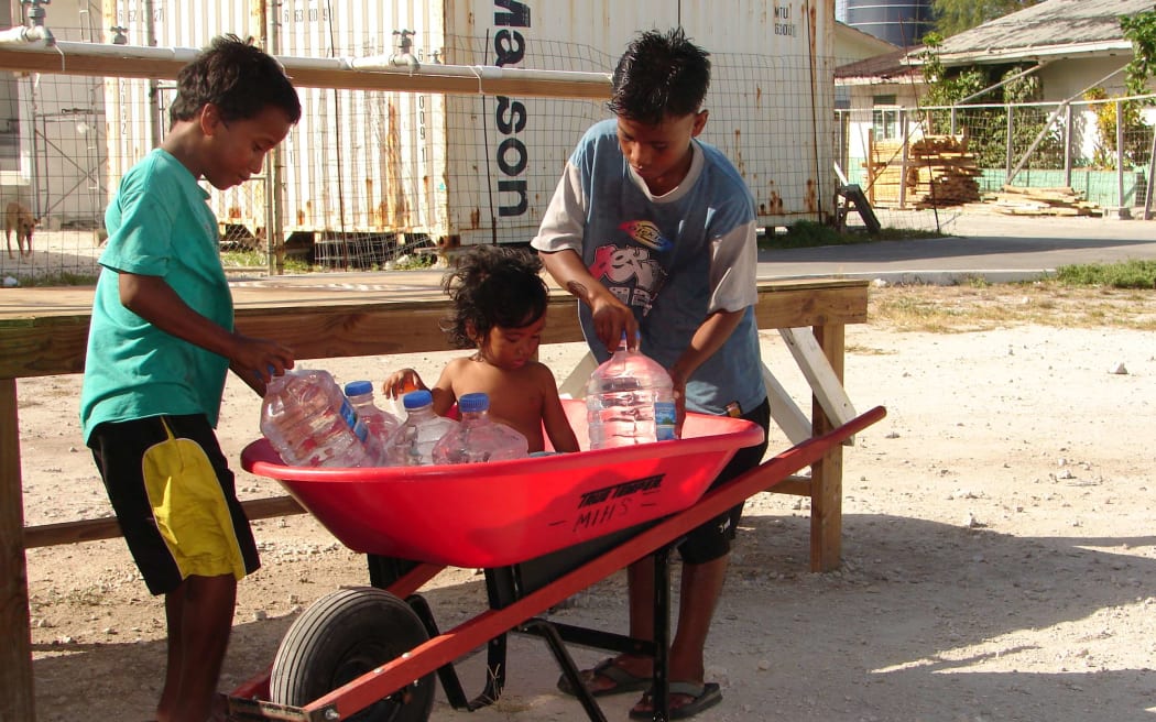 During droughts, the government has been forced to set up small reverse osmosis units around Majuro to ensure access to fresh water for residents — who bring containers to fill (as shown in this 2007 photo). A new water project could increase Majuro's storage capacity by nearly 50 percent.