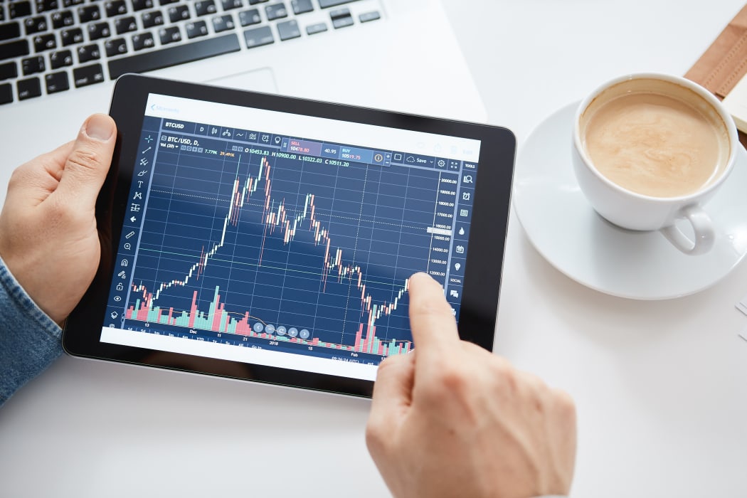 A person looking at stockmarket changes on a tablet.