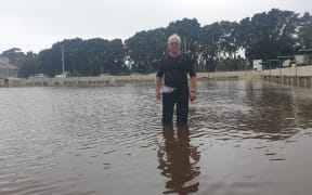 Spud Andrews takes a stroll across the flooded Paritutu Bowling Club greens.