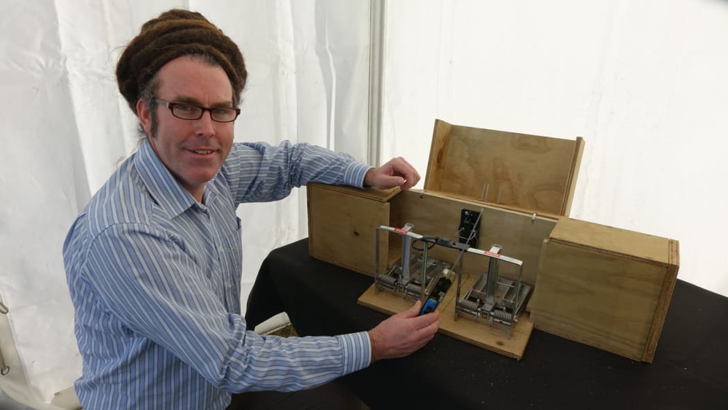 ZIP field team leader Duncan Kay with a new trap that notifies trappers when it's deployed.