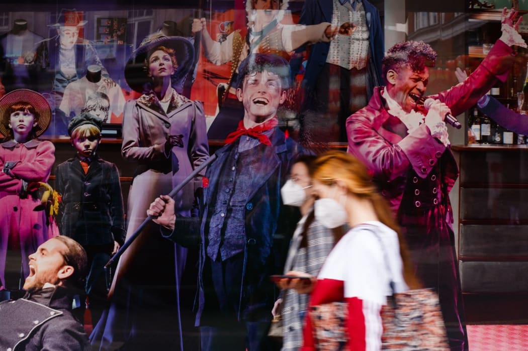 Women wearing face masks walk past the closed closed Sondheim Theatre, home to long-running musical 'Les Miserables', on Shaftesbury Avenue in London, England, on July 6, 2020.