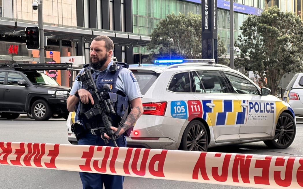 Armed police stand behind a cordon in downtown Auckland following an active shooter situation on 20 July, 2023.