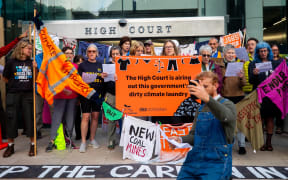 Protestors peg t-shirts with anti-government slogans painted on them them to a washing line they have set up outside the Hight Court in Wellington.